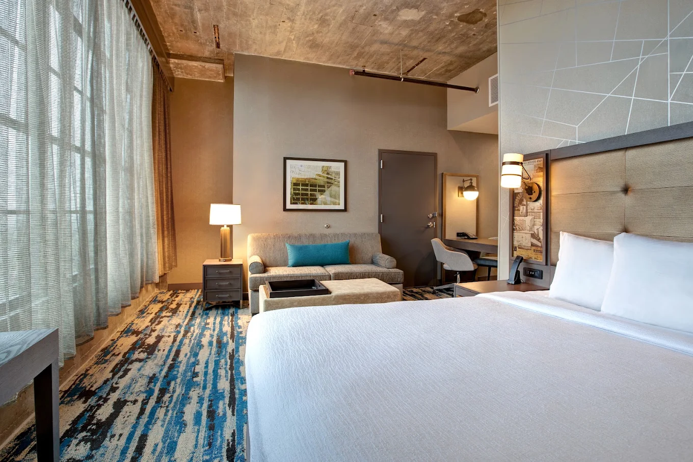 Guest room at Embassy Suites by Hilton Rockford Riverfront with a king bed and seating area